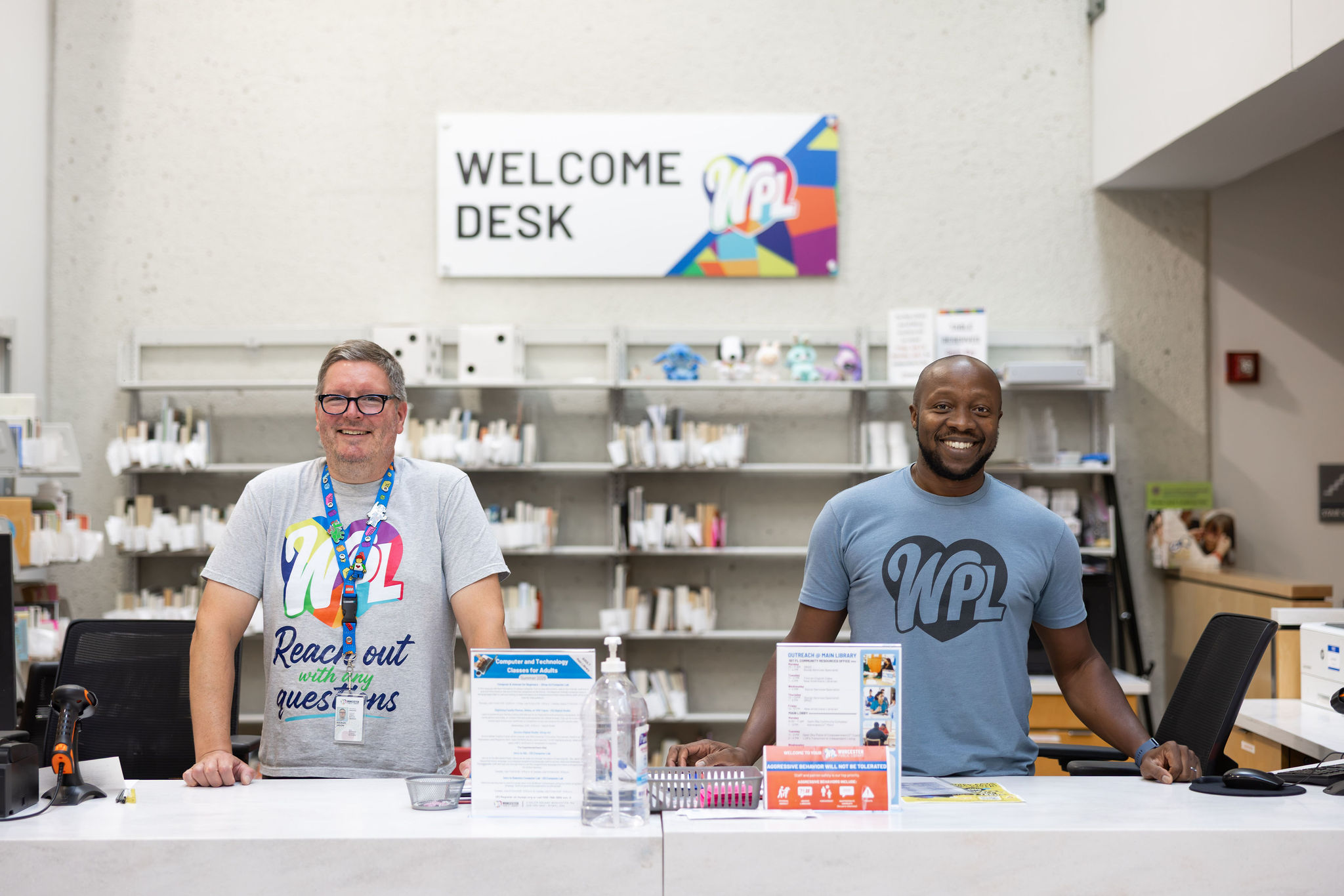 Two Worcester Public Library staff members work at the Welcome Desk.