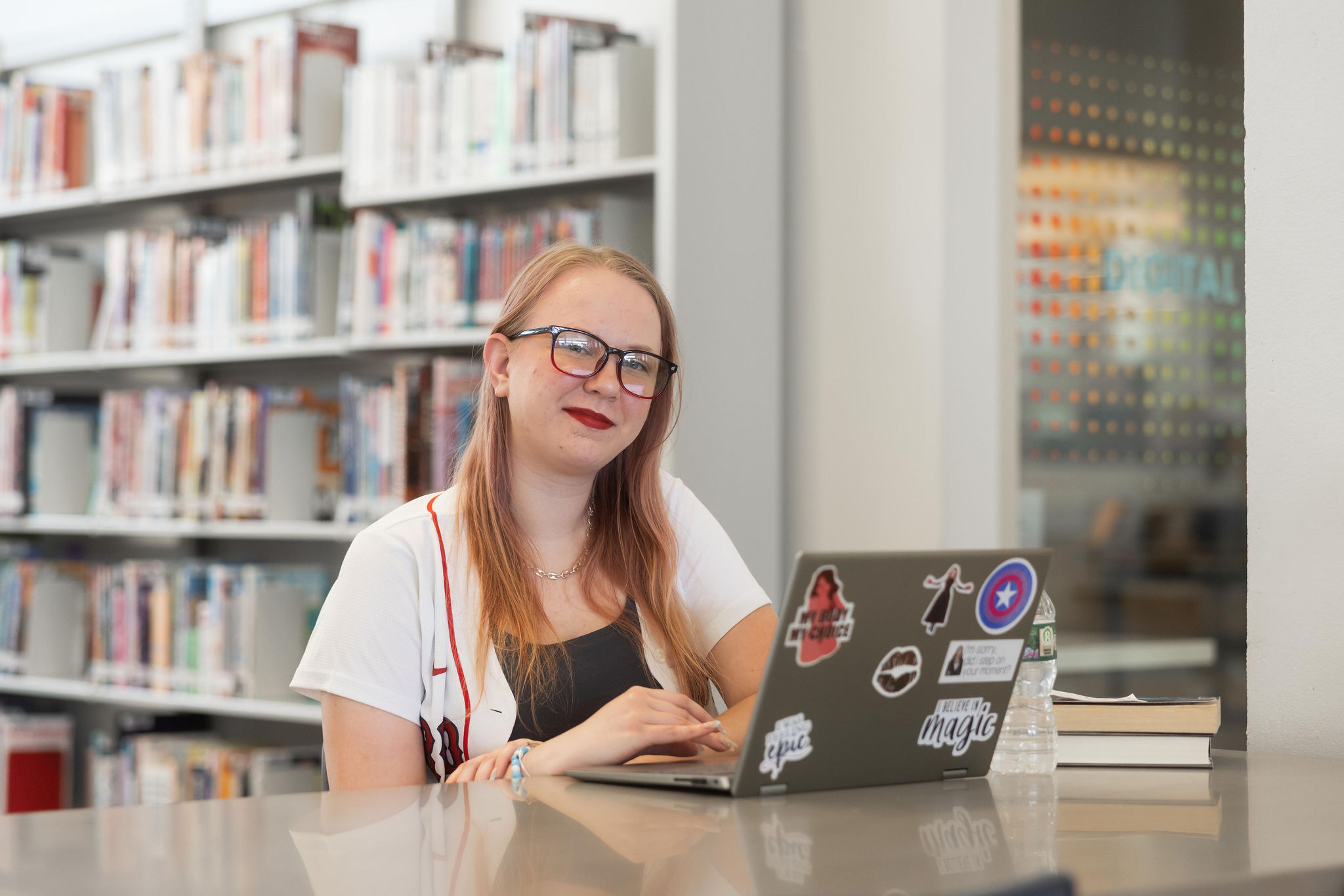A woman works on a laptop inside the library.