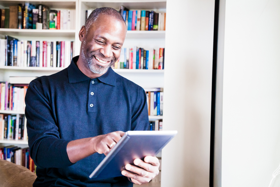 A man reads on a tablet, points to Reader's Corner.
