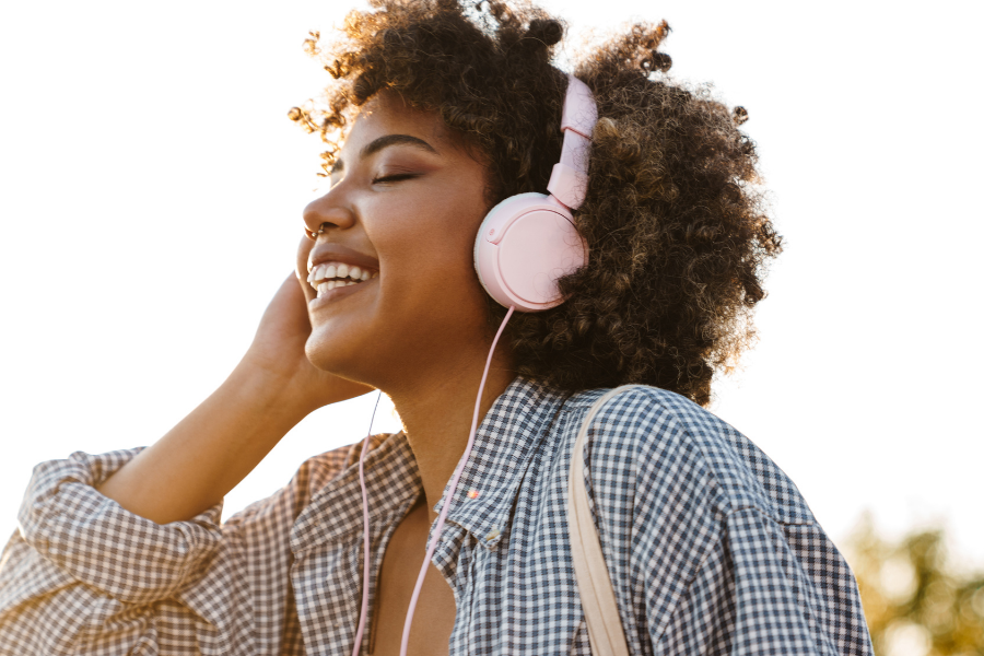 Woman listens to headphones, points to Freegal.