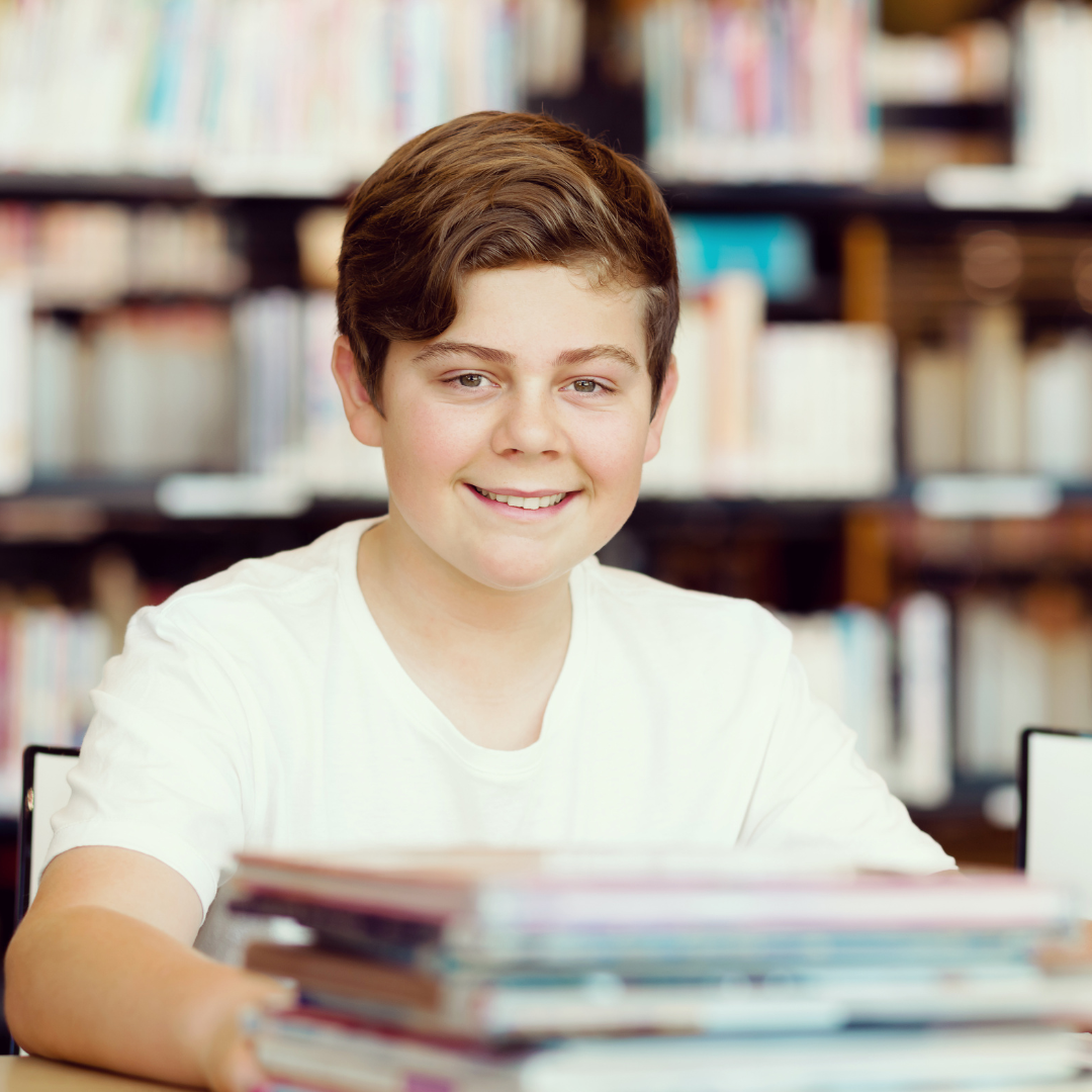 A tween reads a book in a library.